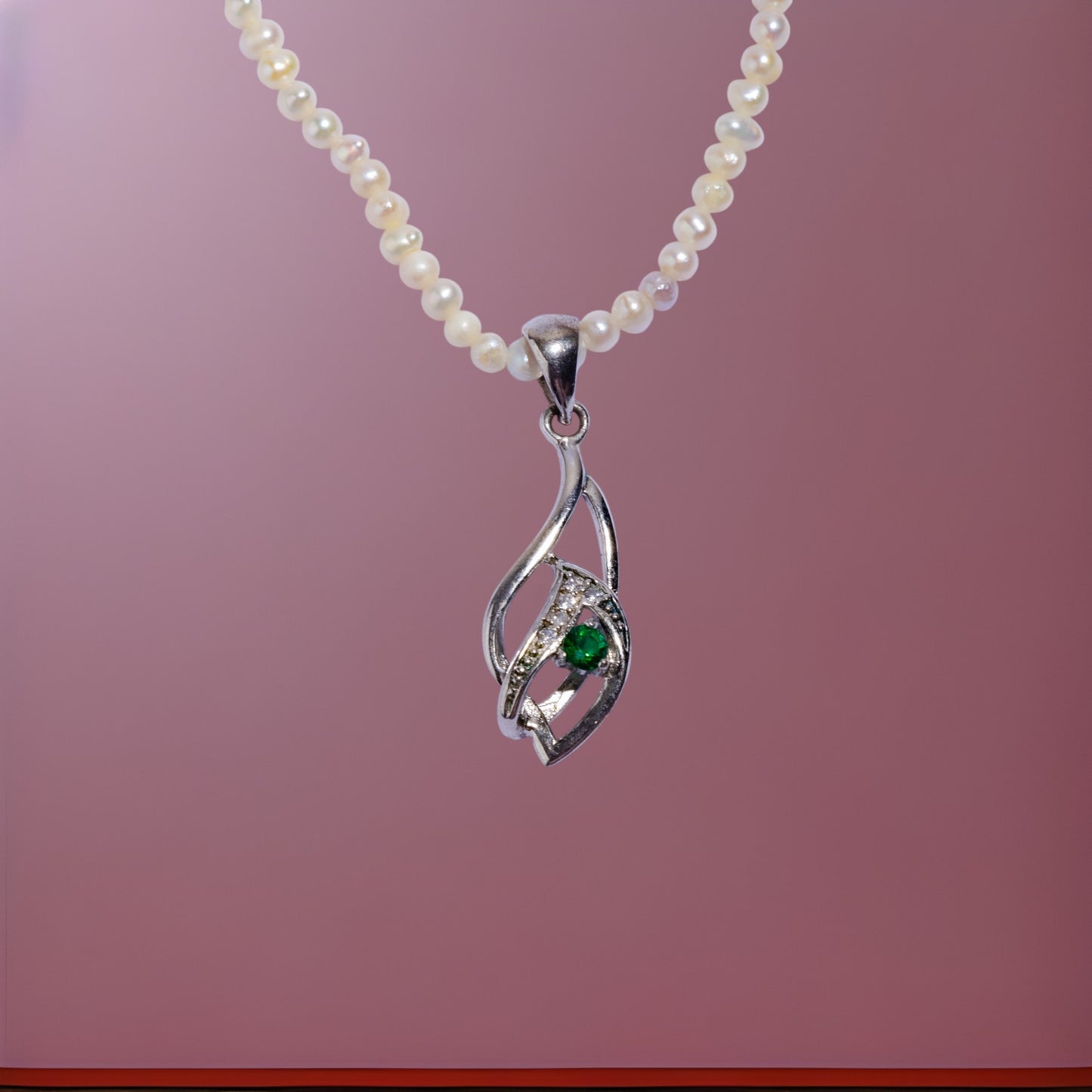 Pearl necklace with a silver pendant and a green emerald gemstone