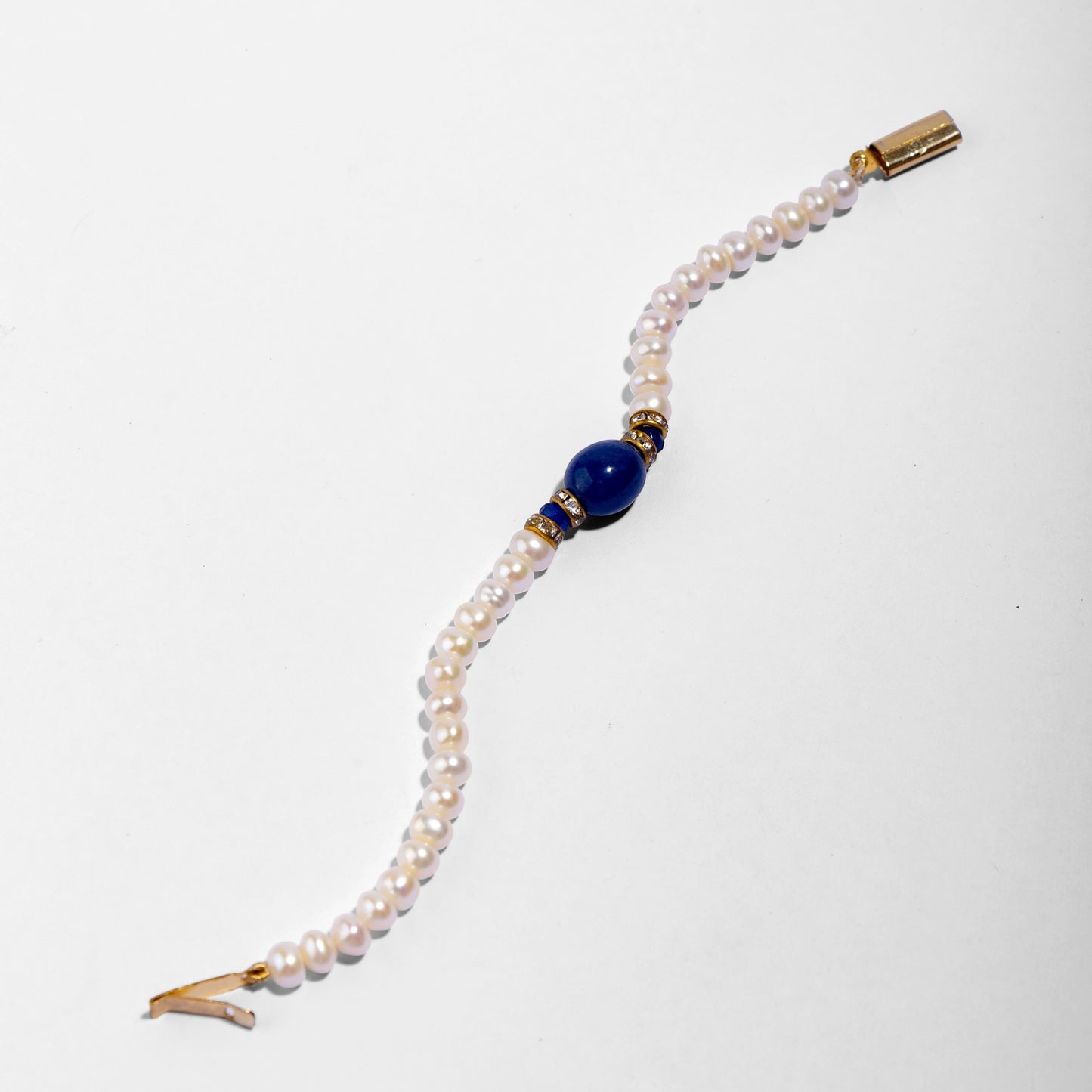 Pearl bracelet with a blue gemstone and gold clasp