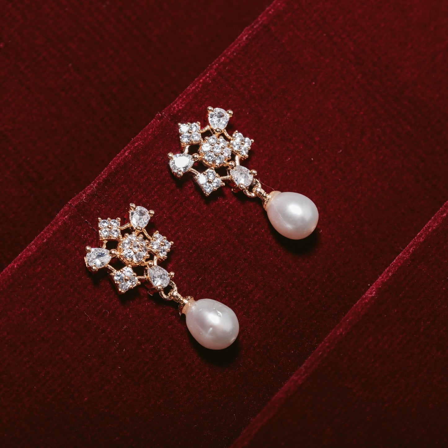 Pair of earrings with American diamonds and pearl drops background
