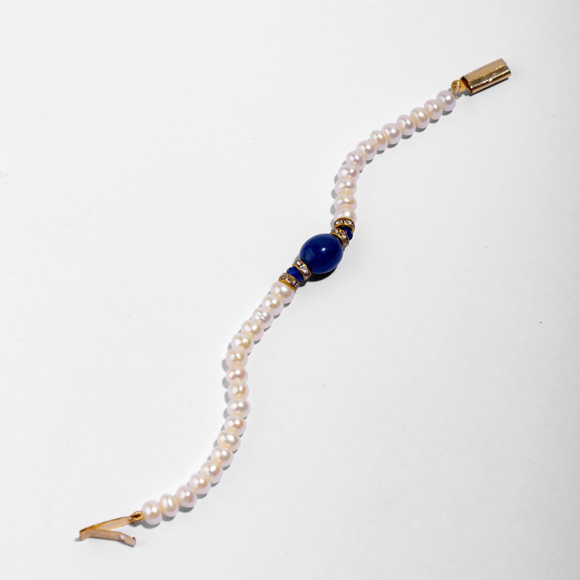 Pearl bracelet with a blue gemstone and gold clasp 