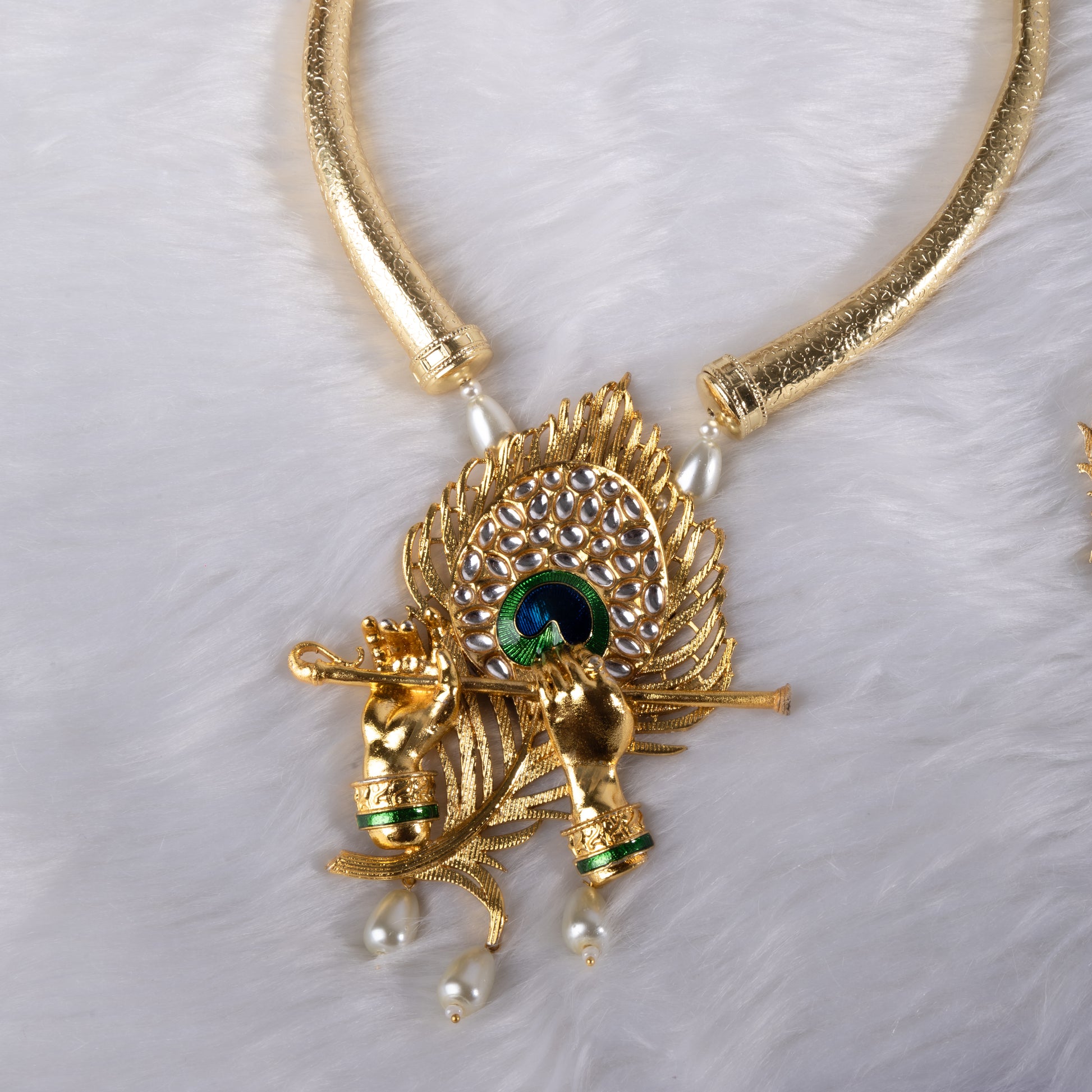 Gold necklace with peacock feather design and green gemstone 