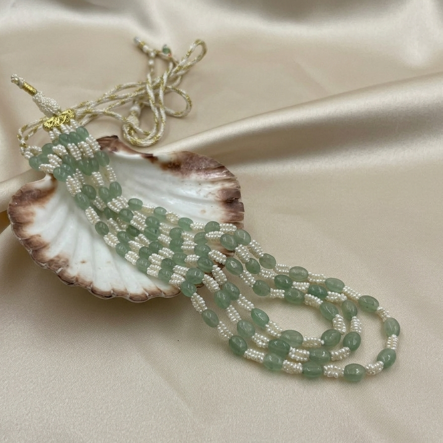 Flat lay of the Meera Strawberry Emerald & Freshwater Pearl Necklace handcrafted with genuine Strawberry Emerald gemstones and freshwater seed pearls.